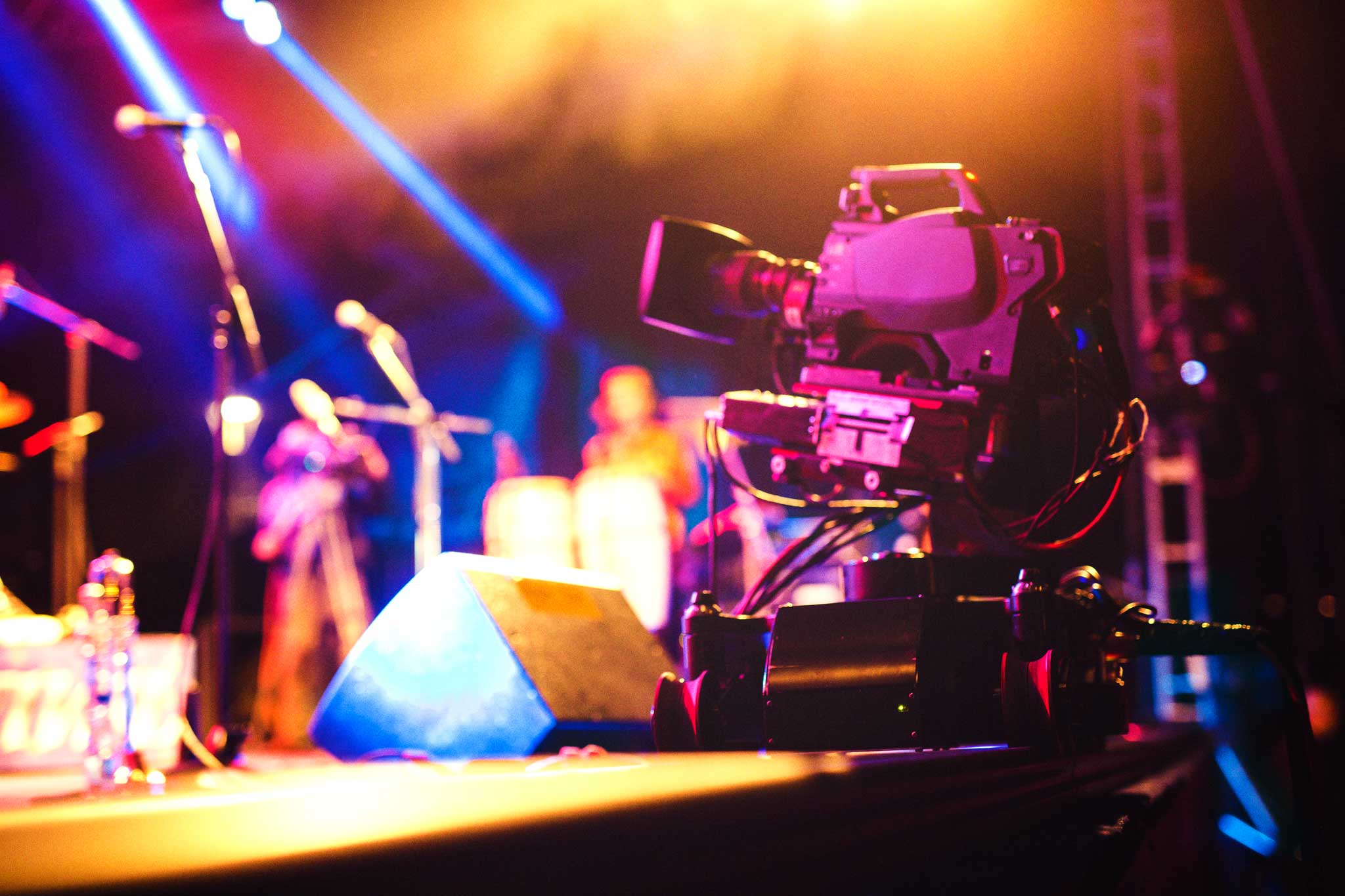 Professional video camera on stage filming live concert. Photo: iStock.com/mixetto