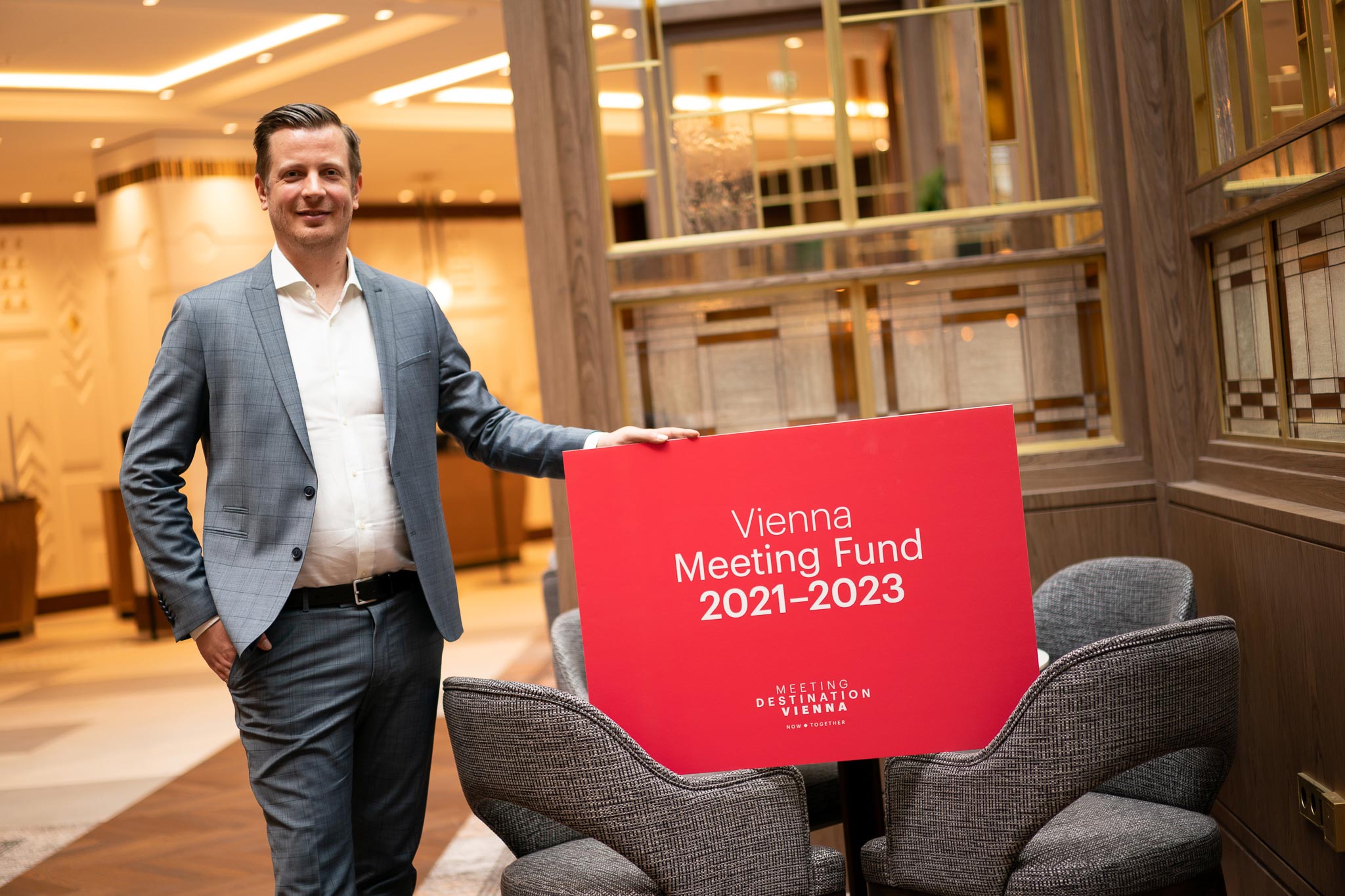 Christian Woronka, Director of the Vienna Convention Bureau standing with his hand on a sign for the Vienna Meeting Fund 2021–2023.